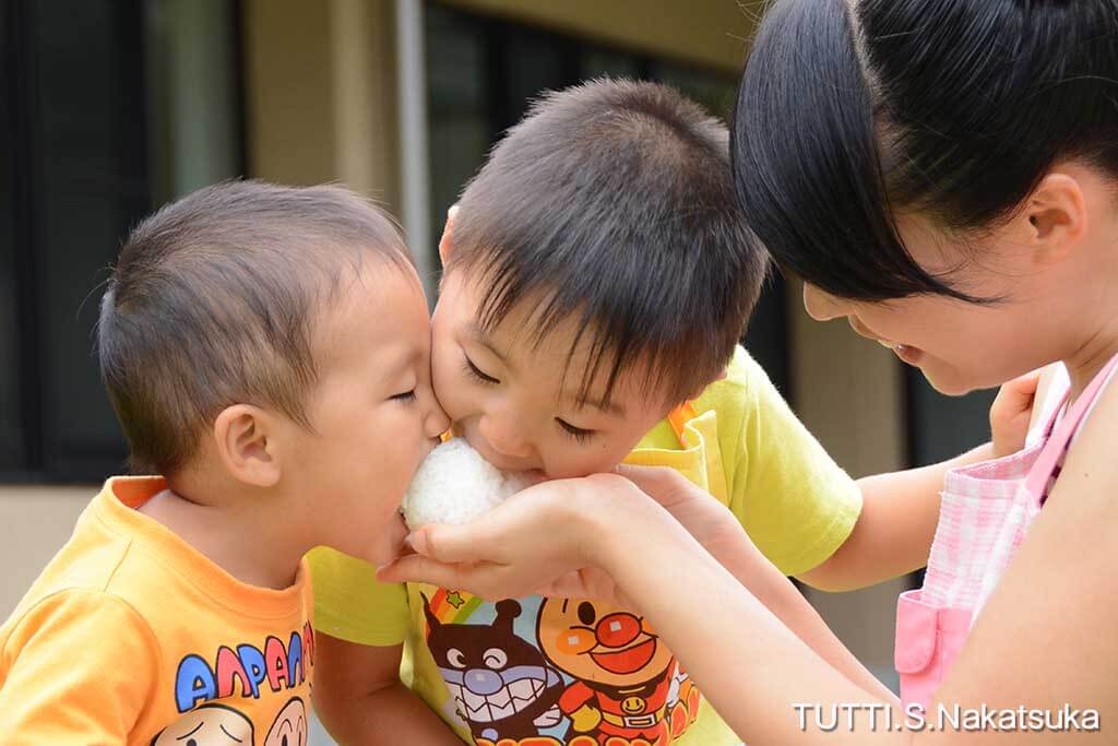 おにぎりを食べる家族の写真